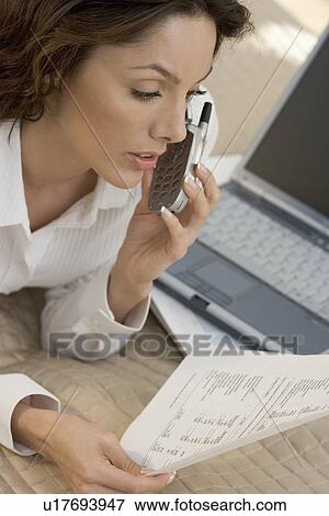 Stock Photo - Woman with mobile phone and computer. Fotosearch