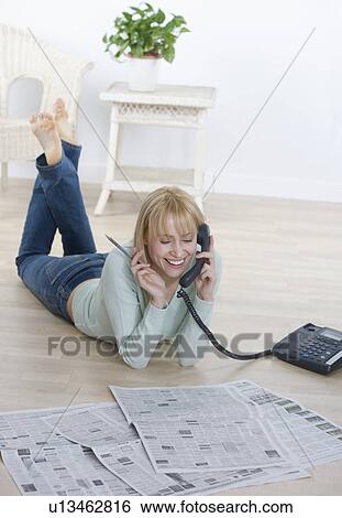 Stock Photograph - Woman with newspaper talking on phone. Fotosearch