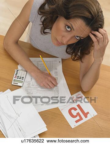 Stock Image - Woman working against tax deadline. Fotosearch