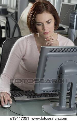 Woman working at computer in office View Large Photo Image Stock Image - Woman working at computer in office. Fotosearch