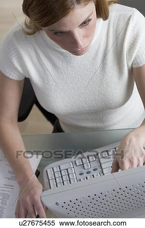 Stock Photography - Woman working on computer at desk. Fotosearch