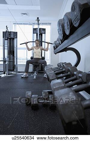 Picture - Woman working with resistance machine. Fotosearch