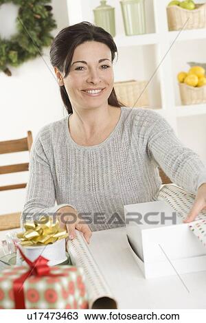 Woman wrapping Christmas gifts View Large Photo Image Stock Image - Woman wrapping Christmas gifts. Fotosearch