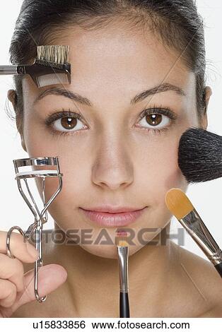 Stock Photograph - Woman's face with many cosmetic tools. Fotosearch