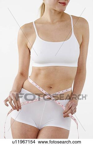 Woman's torso encircled by tape measure View Large Photo Image Picture - Woman's torso encircled by tape measure. Fotosearch