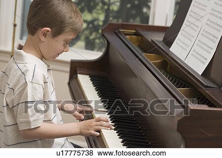 Young boy playing piano View Large Photo Image Stock Photo - Young boy playing piano. Fotosearch