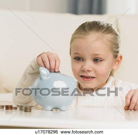 Young girl putting change in piggy bank View Large Photo Image Stock Photograph - Young girl putting change in piggy bank. Fotosearch