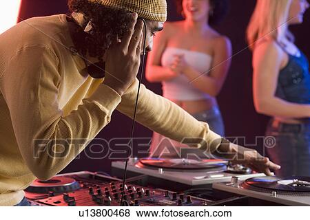 Young man playing music at a dance club View Large Photo Image Stock Photo - Young man playing music at a dance club. Fotosearch