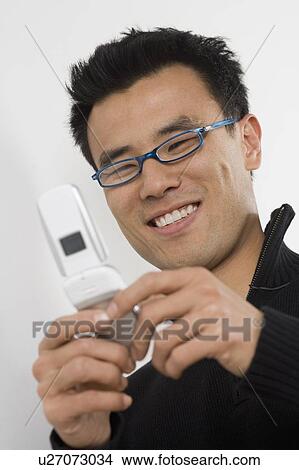 Picture - Young man using a mobile phone. Fotosearch