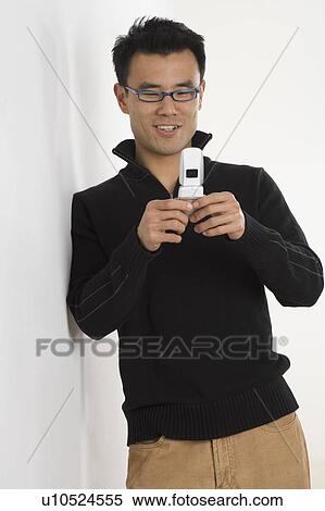 Stock Photography - Young man using a mobile phone. Fotosearch