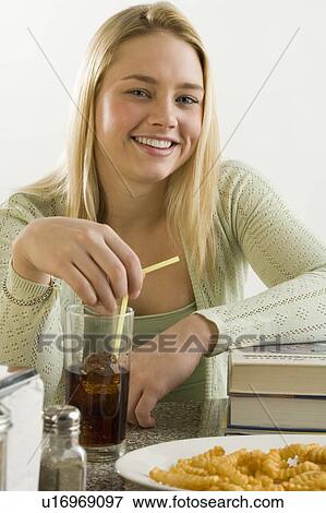 Young woman having a quick meal View Large Photo Image Stock Photo - Young woman having a quick meal. Fotosearch