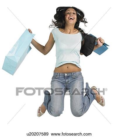 Stock Photo - Young woman jumping with shopping bags. Fotosearch