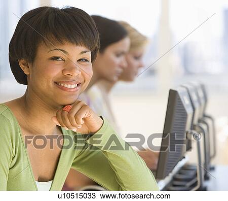 Stock Image - African woman in front of computers. Fotosearch