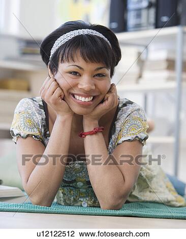 Stock Image - African woman laying on floor. Fotosearch