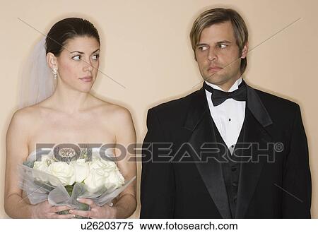 Stock Photography - Angry bride and groom looking at each other. Fotosearch