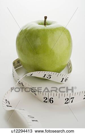 Stock Image - Apple and tape measure. Fotosearch