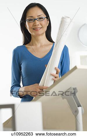Asian businesswoman holding blueprints View Large Photo Image Stock Image - Asian businesswoman holding blueprints. Fotosearch