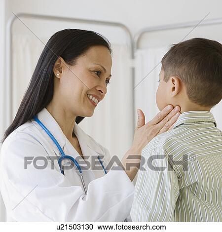 Stock Image - Asian female doctor examining boy’s glands. Fotosearch
