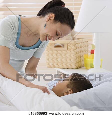 Asian mother tucking son into bed View Large Photo Image Stock Image - Asian mother tucking son into bed. Fotosearch