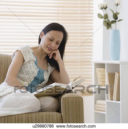 Asian woman reading on sofa View Large Photo Image Stock Photograph - Asian woman reading on sofa. Fotosearch
