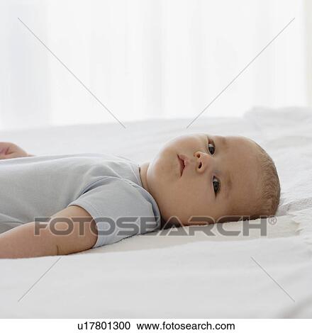 Baby laying on bed View Large Photo Image Stock Image - Baby laying on bed. Fotosearch