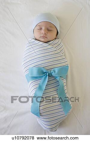 Stock Photo - Baby wrapped in blanket with bow. Fotosearch