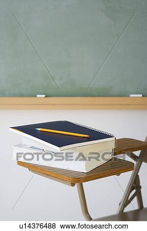 Stock Photo - Books and pencil on desk in classroom. Fotosearch