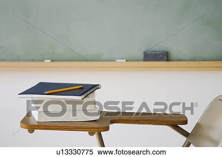 Stock Photography - Books and pencil on desk in classroom. Fotosearch