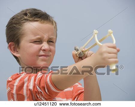 Stock Image - Boy aiming slingshot. Fotosearch