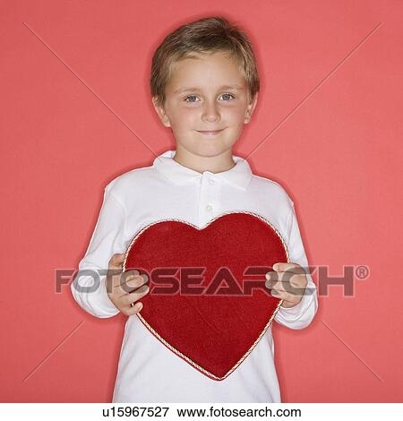 Stock Photo - Boy holding heart-shaped box. Fotosearch