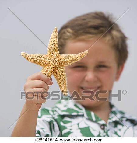 Picture - Boy holding starfish. Fotosearch
