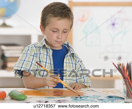 Boy painting at table View Large Photo Image Stock Photo - Boy painting at table. Fotosearch