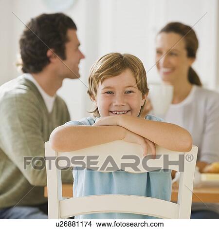 Picture - Boy sitting backwards in chair. Fotosearch