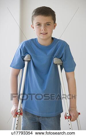 Picture - Boy standing on crutches. Fotosearch