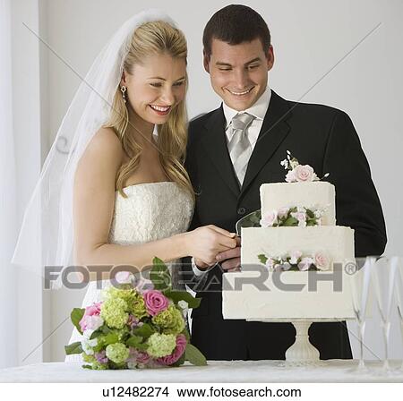 Picture - Bride and groom cutting cake. Fotosearch