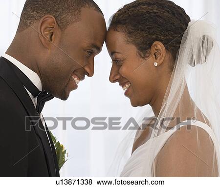 Bride and groom smiling at each other View Large Photo Image Stock Photo - Bride and groom smiling at each other. Fotosearch