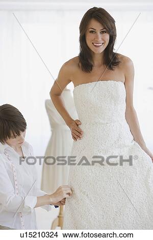 Bride having dress fitted View Large Photo Image Picture - Bride having dress fitted. Fotosearch