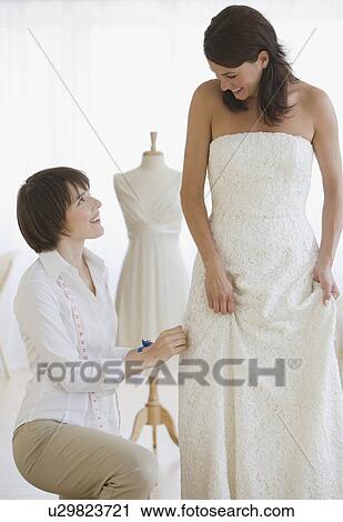 Bride having dress fitted View Large Photo Image Stock Image - Bride having dress fitted. Fotosearch
