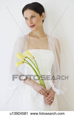 Stock Image - Bride holding long stemmed flowers. Fotosearch