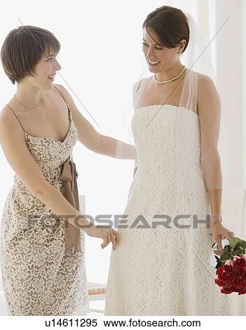 Bridesmaid adjusting bride’s veil View Large Photo Image Stock Photography - Bridesmaid adjusting bride’s veil. Fotosearch