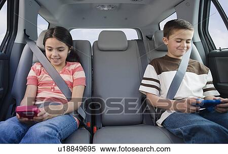 Brother and sister playing video games in car View Large Photo Image Stock Photography - Brother and sister playing video games in car. Fotosearch