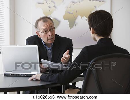 Stock Image - Businessman and businesswoman having meeting. Fotosearch
