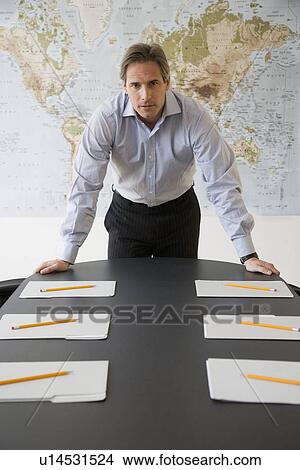 Picture - Businessman at head of conference table. Fotosearch