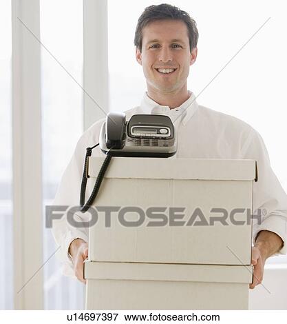 Businessman carrying telephone and storage boxes View Large Photo Image Stock Photo - Businessman carrying telephone and storage boxes. Fotosearch