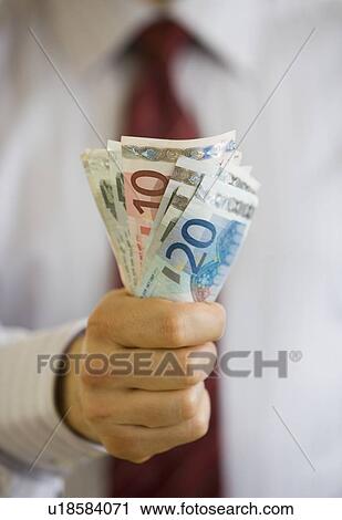 Businessman holding Euro banknotes View Large Photo Image Stock Image - Businessman holding Euro banknotes. Fotosearch