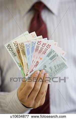 Businessman holding Euro banknotes View Large Photo Image Stock Photo - Businessman holding Euro banknotes. Fotosearch
