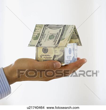 Businessman holding house made money View Large Photo Image Picture - Businessman holding house made money. Fotosearch
