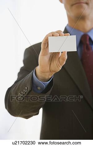 Stock Image - Businessman holding up business card. Fotosearch