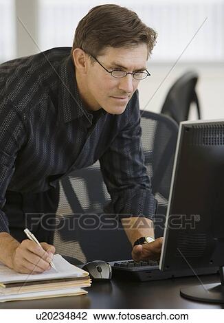 Stock Image - Businessman looking at computer. Fotosearch