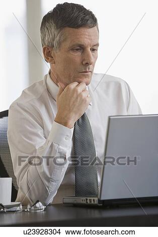 Businessman looking at laptop View Large Photo Image Picture - Businessman looking at laptop. Fotosearch